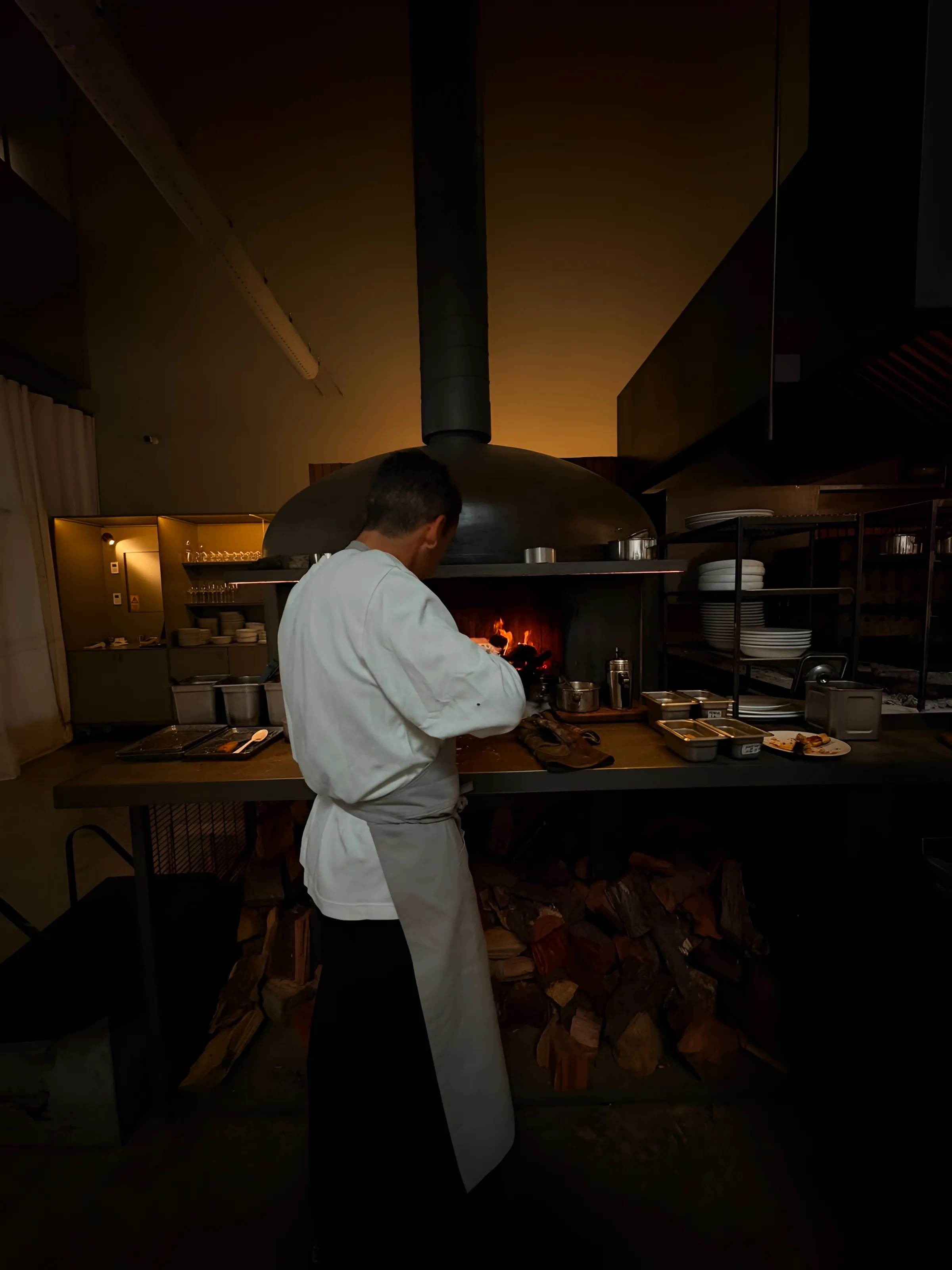 La cocina de fuegos a la vista, con horno y parrilla a leña